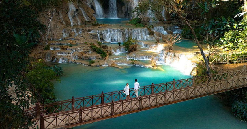 A wooden bridge over the Kuang Si Waterfall